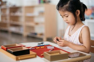 Child using Montessori beads for mathematics work.