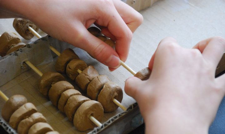 Child making abacus with clay.
