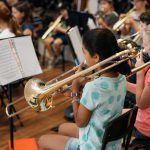 Child playing slide trombone in Montessori band.