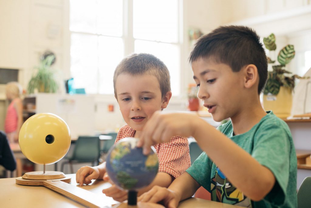 Montessori children and world globe.