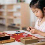 Child using Montessori beads for mathematics work.